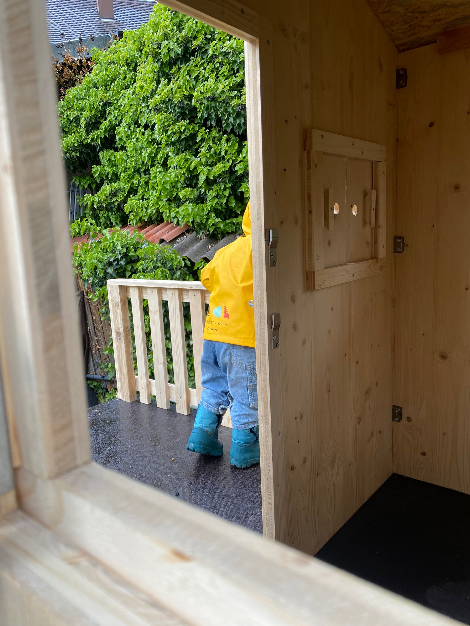 enfant qui joue dans sa cabane en bois