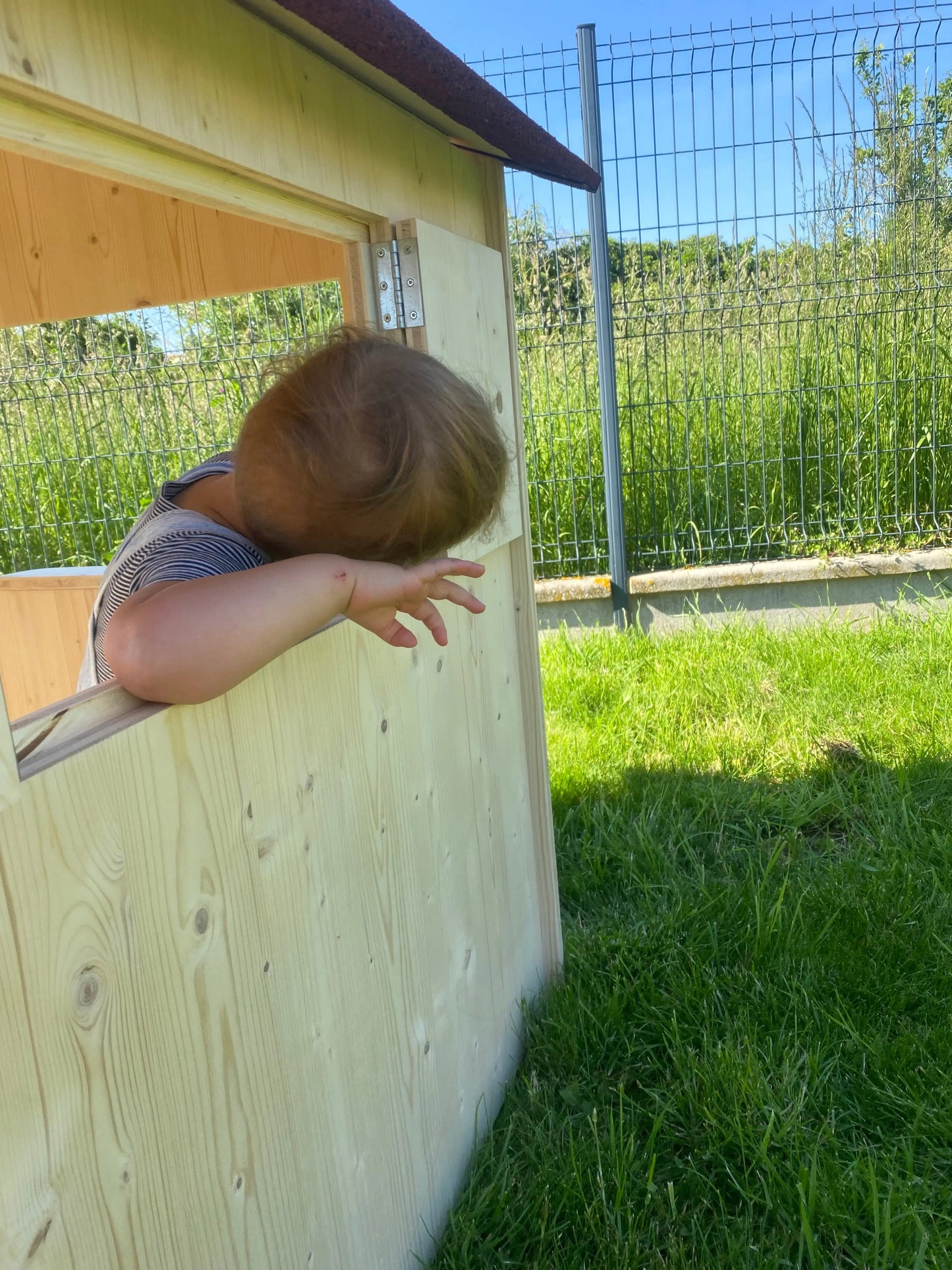 enfant qui joue dans sa cabane en bois