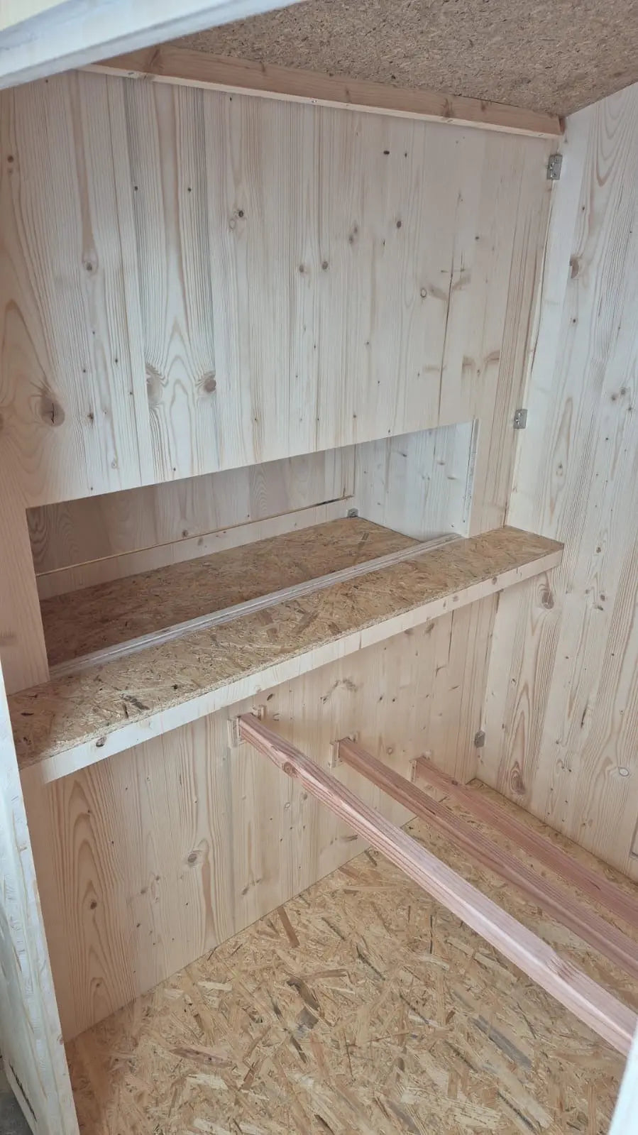 Intérieur du poulailler, accès au pondoir par des perchoirs en espalier