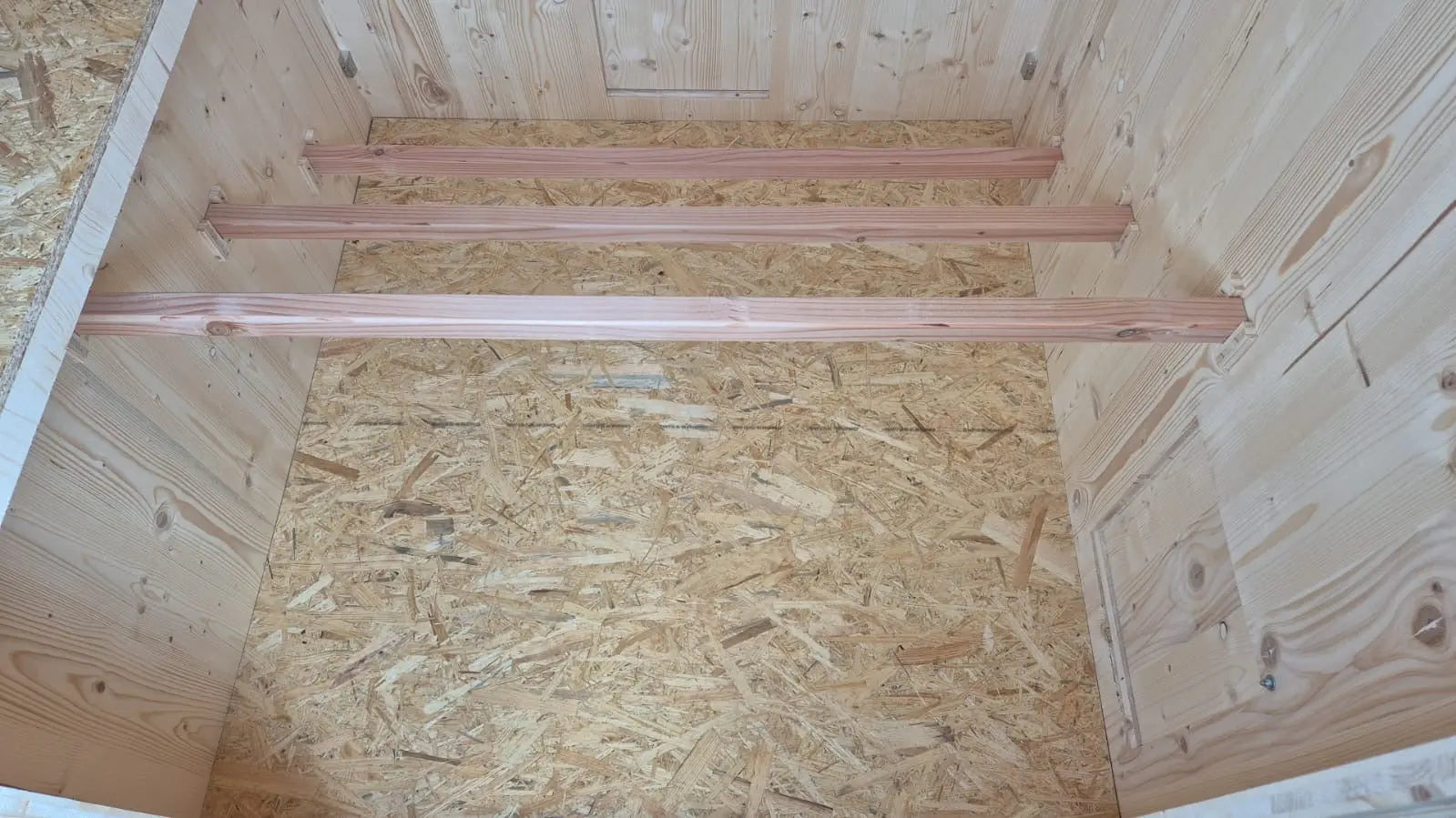 Intérieur du poulailler en bois, trois perchoirs confortables et ergonomiques en espaliers