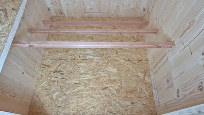 Intérieur du poulailler en bois, trois perchoirs confortables et ergonomiques en espaliers
